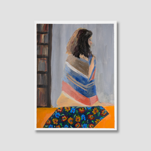 Framed artwork of a woman wrapped in a colourful striped balinese shawl sitting on an orange surface.