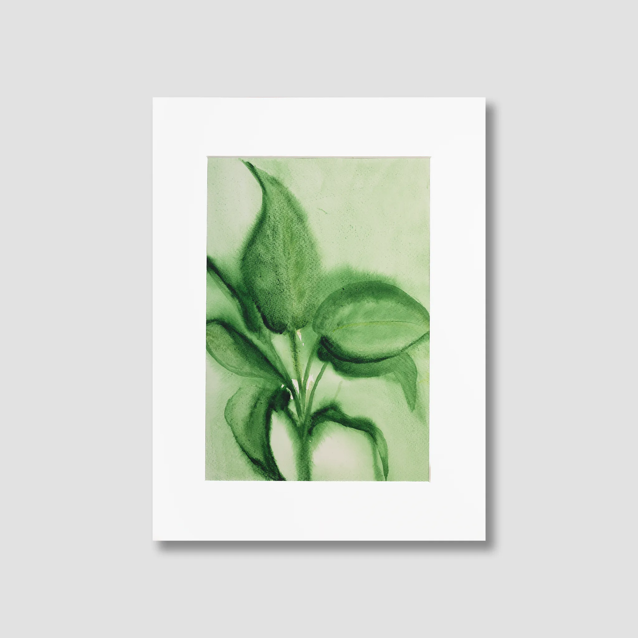 Framed artwork of green leaves on a light green background