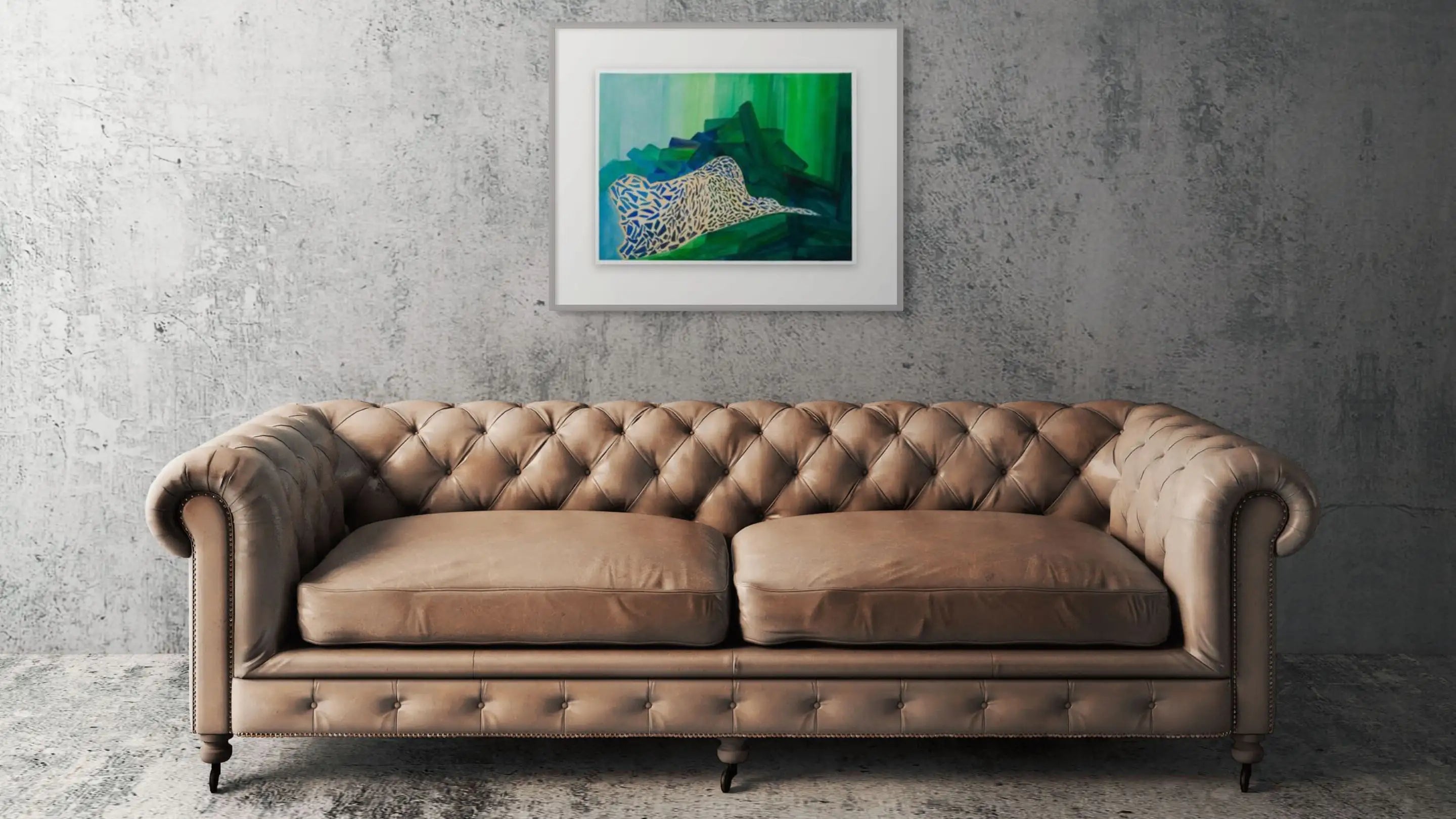 Brown leather sofa in front of a gray wall with a framed abstract painting.